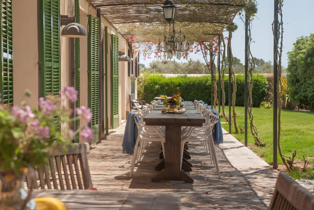 - une table en bois avec des chaises sur la terrasse dans l'établissement Doppelzimmer Gregal Es Llobets, à Llucmajor