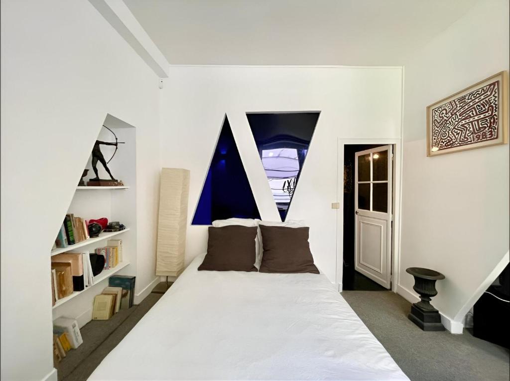 une chambre blanche avec un lit et une fenêtre dans l'établissement La Galerie des Archives-Unique and élégant Gem-MARAIS AirCond, à Paris