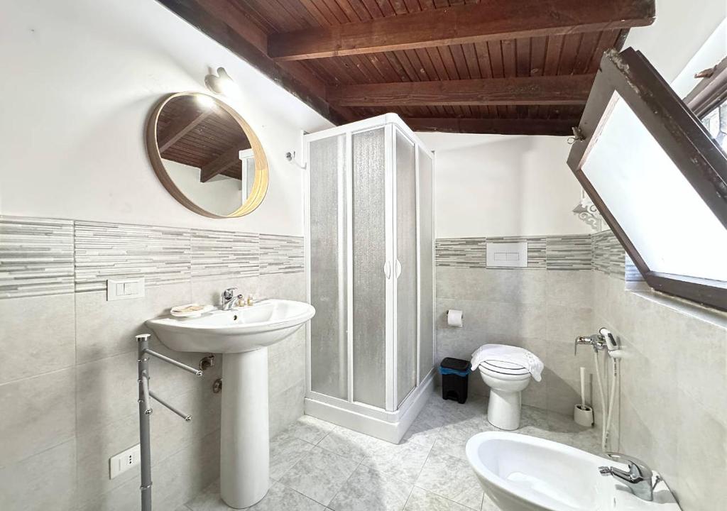 łazienka z umywalką, toaletą i lustrem w obiekcie Solemar Sicilia - Seaside House Capo Zafferano w mieście Santa Flavia