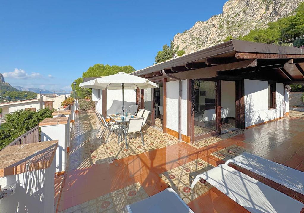balkon domu ze stołem i parasolem w obiekcie Solemar Sicilia - Seaside House Capo Zafferano w mieście Santa Flavia