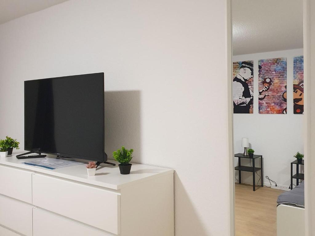 a tv sitting on top of a white dresser at Beautiful Apartment in Bad Oldesloe in Bad Oldesloe