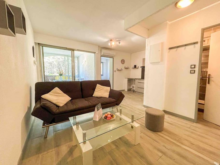 un salon avec un canapé et une table en verre dans l'établissement Charmant T2 à 1km des plages de Sanary, à Sanary-sur-Mer