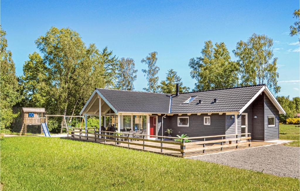 a small house with a playground in a field at Four-Bedroom Holiday Home Glesborg With A Room Hot Tub 07 in Fjellerup