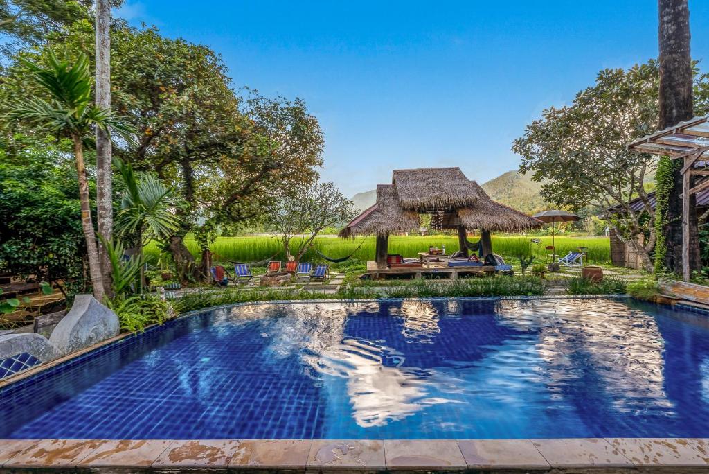 a swimming pool in front of a villa at Buzzas @ Pai Chan in Pai