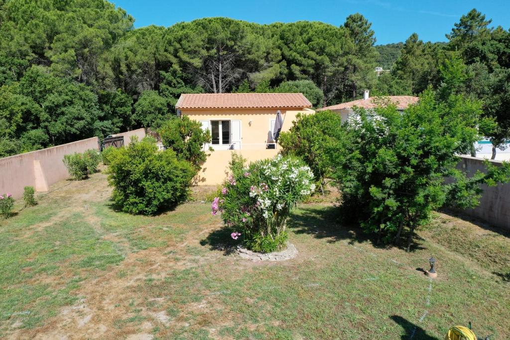 une petite maison dans une cour arborée dans l'établissement Mini villa indépendante idéale et très bien située, à Porto-Vecchio