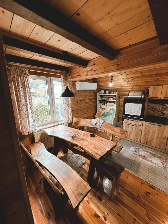 a dining room with a wooden table and benches at Holiday Home Jakov in Kolašin