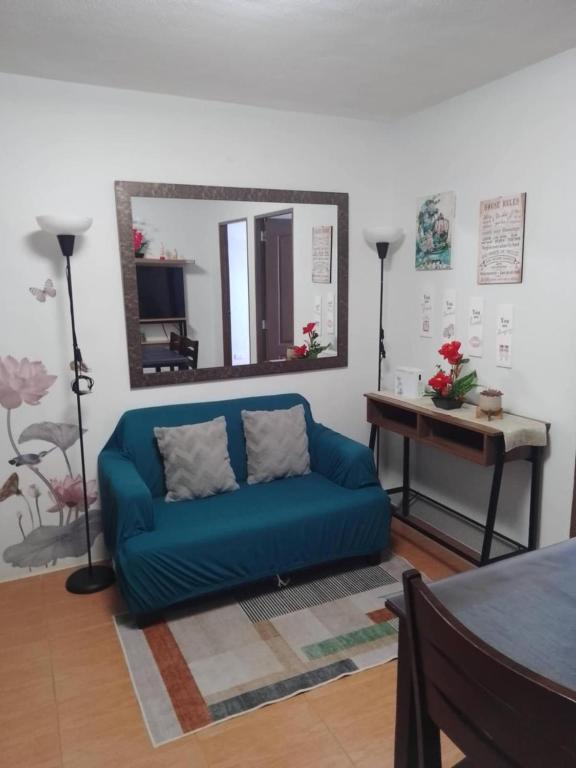 a blue couch in a living room with a mirror at Cagayan de oro One Oasis - 2 Bedroom Unit in Cagayan de Oro