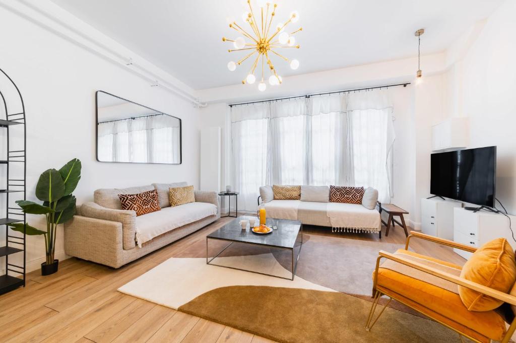 un salon avec deux canapés et une télévision dans l'établissement Charmant appartement équipé proche Sacre cœur - 4P - FLAT-GUEST, à Paris