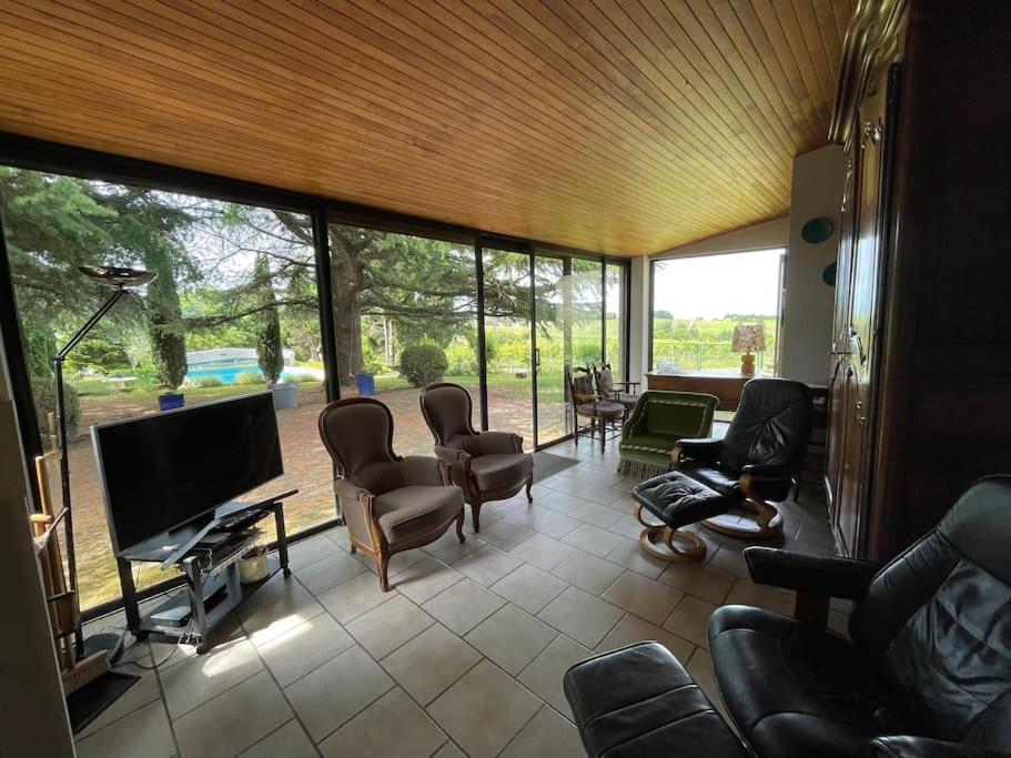 un salon avec des chaises et une télévision à écran plat dans l'établissement Maison 8 pers, piscine, au cœur du pays de Cognac, à Malaville