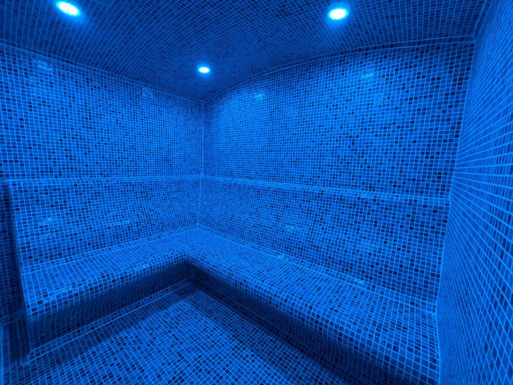 a blue room with a tub with blue lights at Corfu Hotel in Ayia Napa