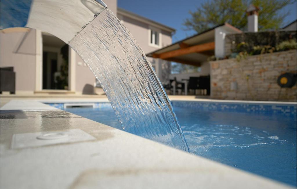 fontanna wodna przed basenem w obiekcie Stunning Home In Fradelani With Wifi w mieście Šivati