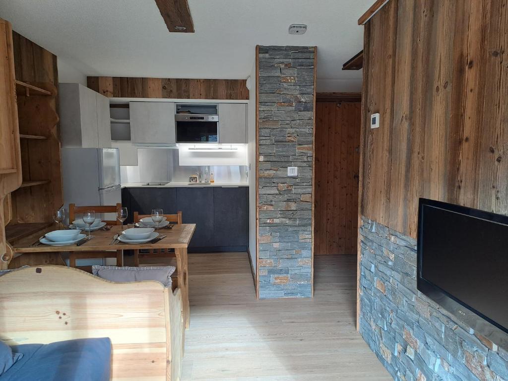 Il dispose d'une cuisine et d'un salon avec une table et une télévision. dans l'établissement Appartement équipé centre Carroz et garage, à Arâches-la-Frasse