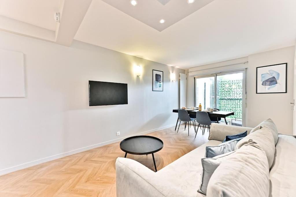 un salon avec un canapé et une table dans l'établissement Appartement spacieux et paisible Paris 19ème - II, à Paris