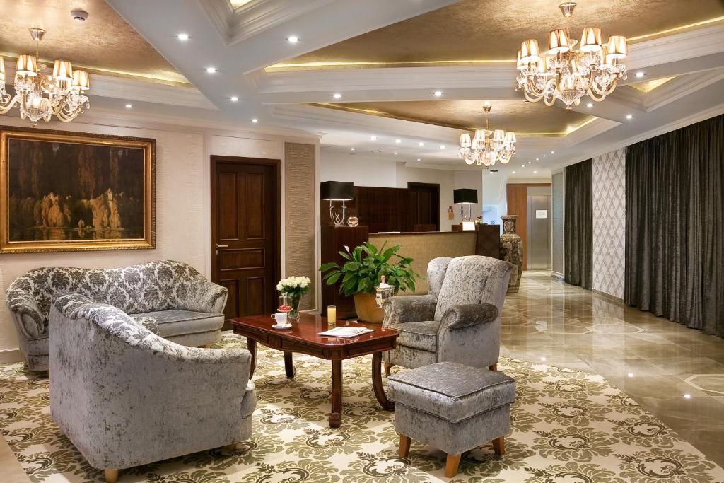 a living room with two chairs and a table at Hotel Capitulum in Győr