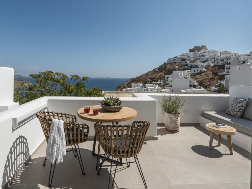 a patio with a table and chairs on a balcony at Saluti Da Stampalia Chora in Pera Gyalos