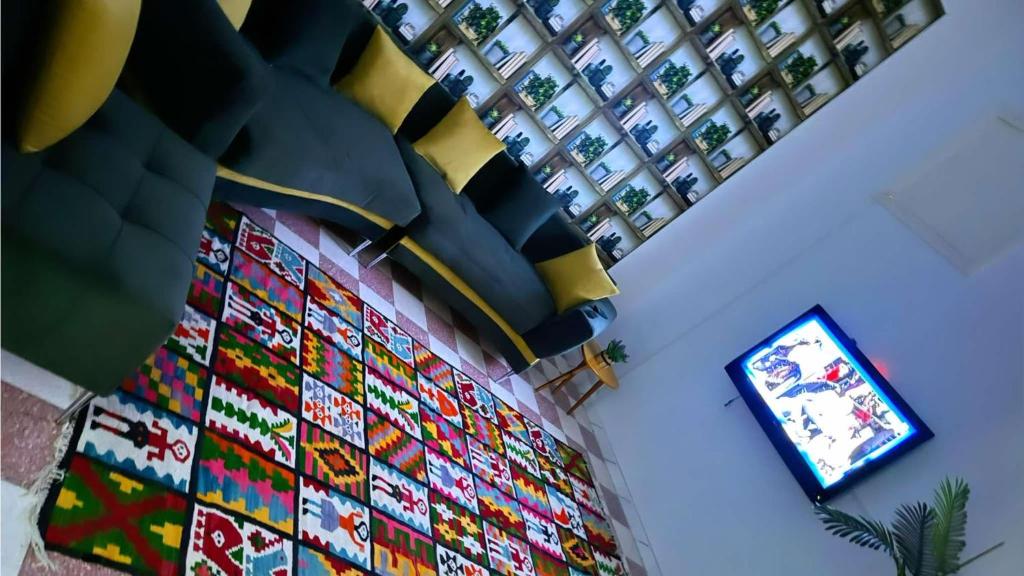 チュニスにあるDar Elineのカラフルな壁の客室で、テレビが備わります。