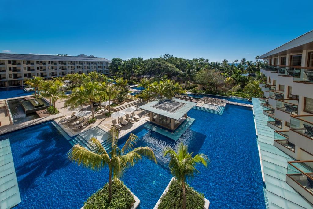 an aerial view of a resort swimming pool with palm trees at Henann Resort Alona Beach in Panglao Island