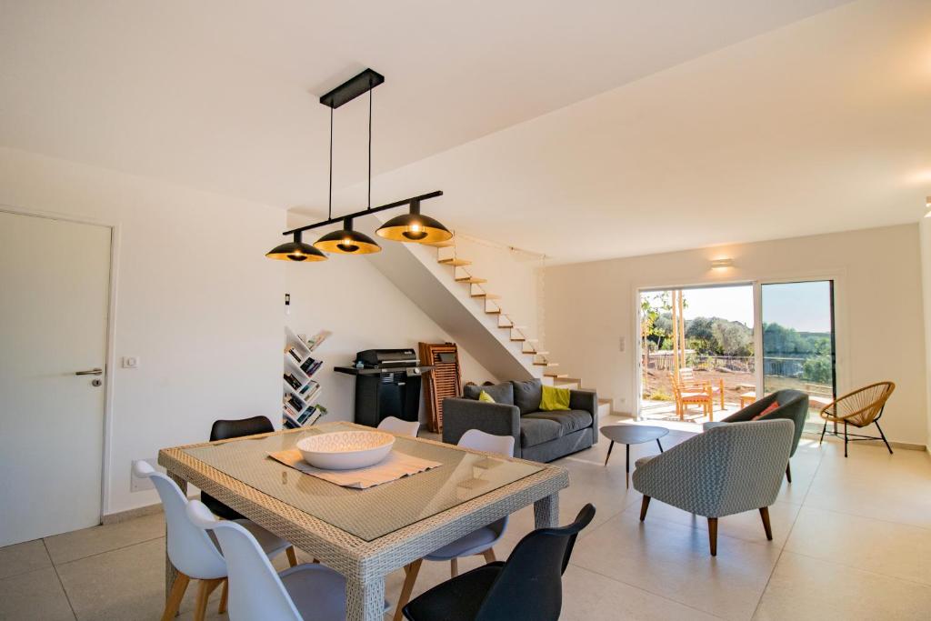 une salle à manger et un salon avec une table et des chaises dans l'établissement Guetali du Village, à Monacia-dʼAullène