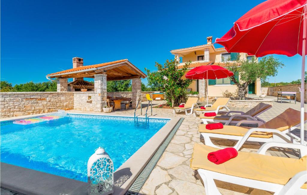 basen z leżakami i parasolami obok domu w obiekcie Amazing Home In Golubovo With Jacuzzi w mieście Krnjaloža