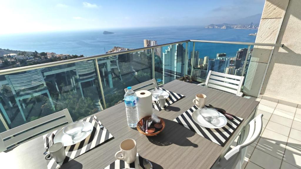 balkon ze stołem i krzesłami oraz widokiem na miasto w obiekcie Skyline 39 Increíbles vistas al mar desde la terraza privada en la planta 39 w mieście Benidorm