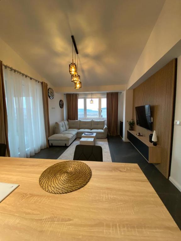 a room with a large bed and a living room at Penthouse San Casa Sebeș in Sebeş