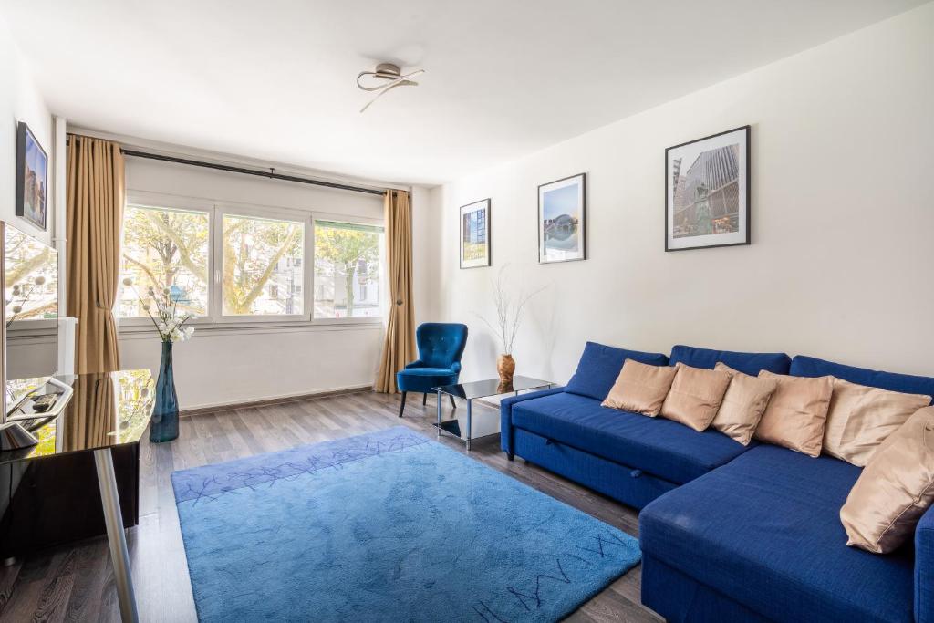 - un salon avec un canapé bleu et un tapis bleu dans l'établissement Bright & Contemporary 2BD Apartment, à Paris