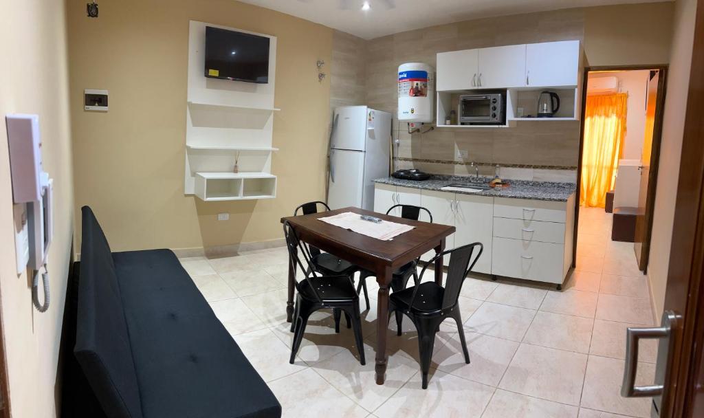 a small kitchen with a wooden table and chairs at ALOJAMIENTO NORTE 1 in Santiago del Estero