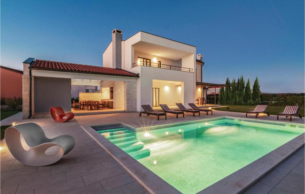 a house with a swimming pool in front of a house at Amazing Home In Valbandon in Fondole