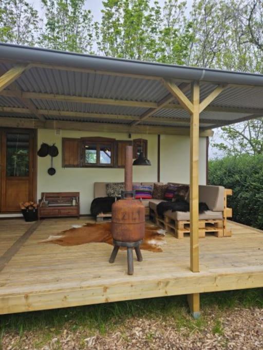 a large wooden deck with a pergola at Cosy Cabin in Scharendijke