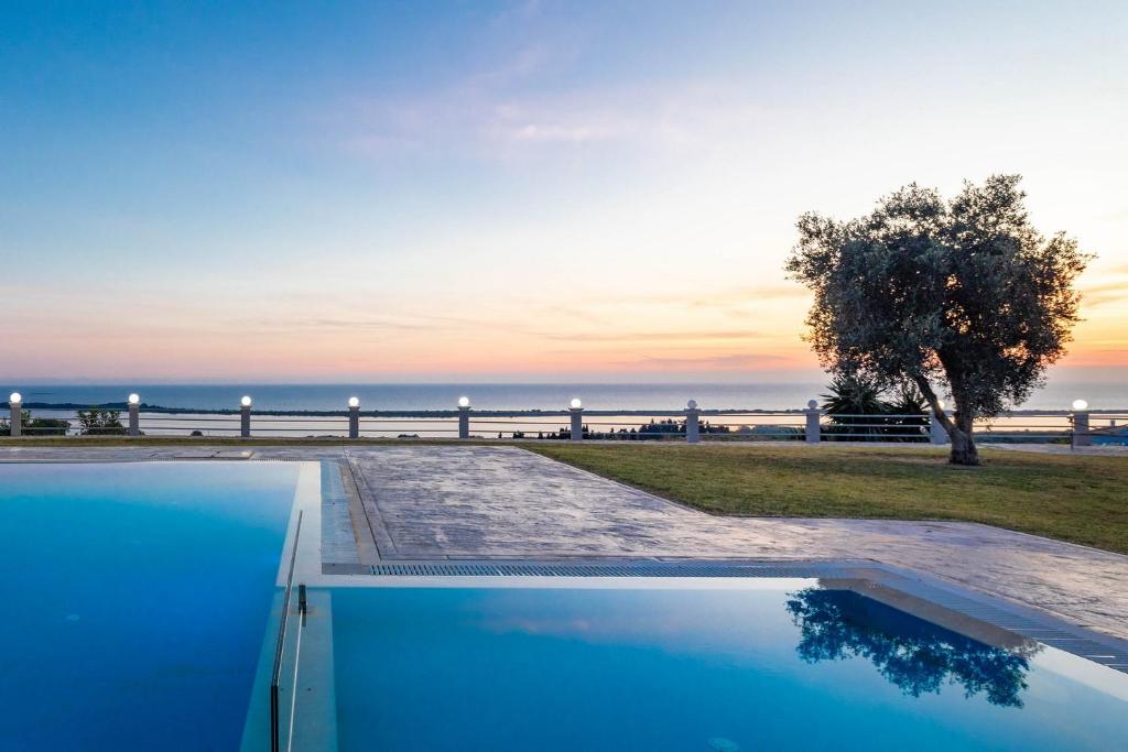 a swimming pool with a view of the ocean at Villa Mediterranean View in Corfu
