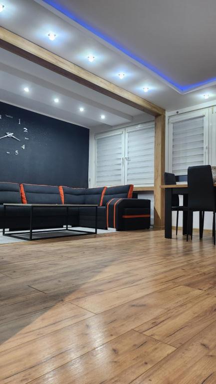 a living room with a couch and a table at Ekskluzywny Apartament w Centrum z Klimatyzacją i Balkonem in Lubin