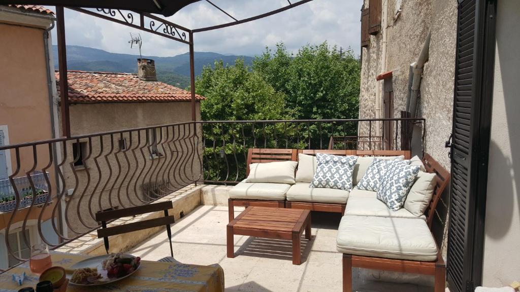 a patio with a couch and a table on a balcony at Provence Medieval Hideaway in Fayence