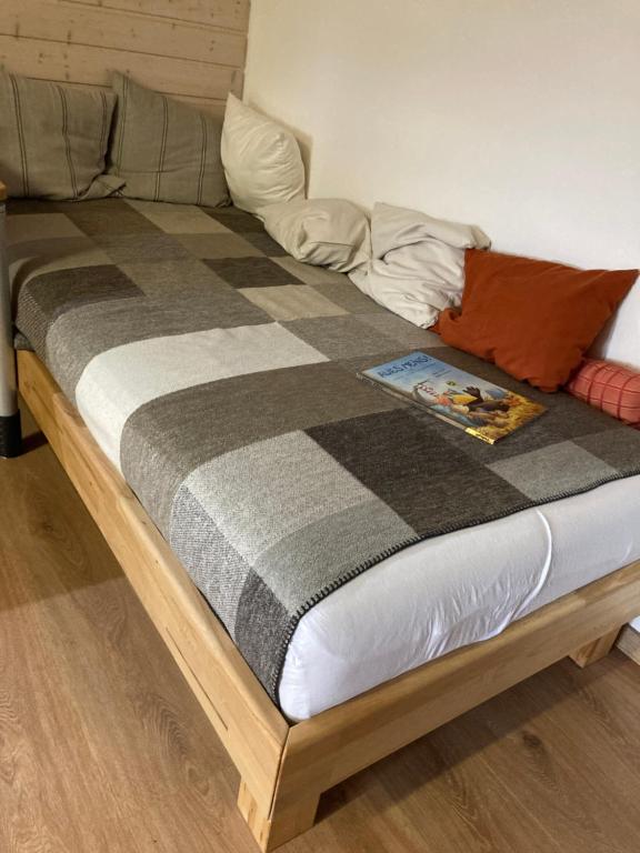 a bed with a checkered blanket on top of it at Gemütliche Wohnung nähe Europapark Rust Offenburg Straßburg in Neuried