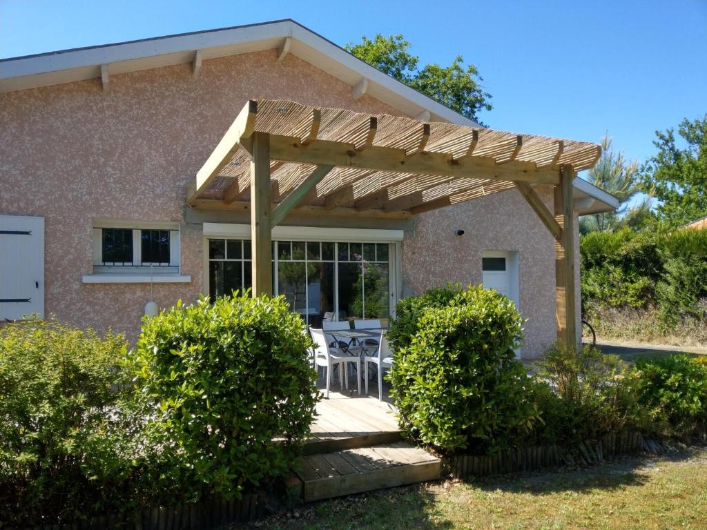 une pergola en bois devant une maison dans l'établissement Villa Rose des Sables, à Andernos-les-Bains