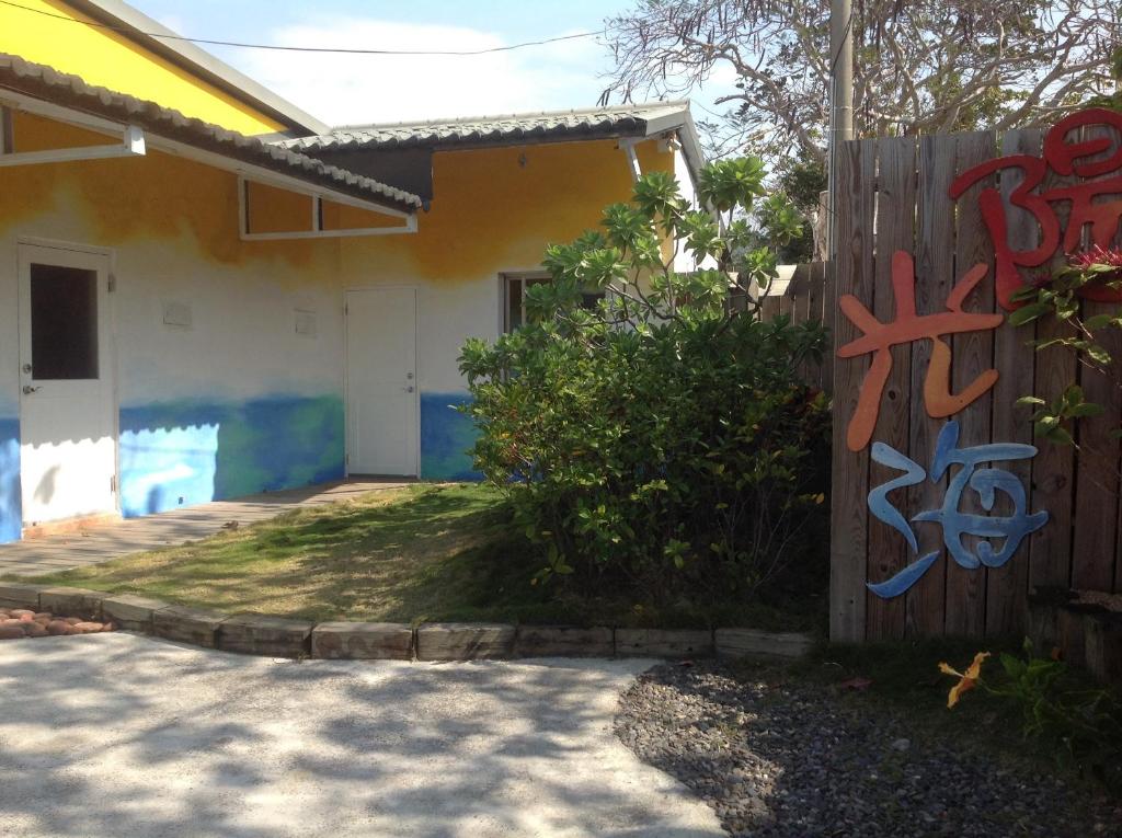 une maison avec graffiti sur le côté d'une clôture dans l'établissement Kenting Sun & Sea B&B, à Nanwan