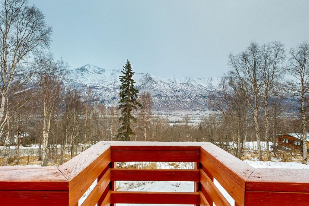 una terrazza in legno con vista sulle montagne innevate di Eagle River Retreat a Eagle River