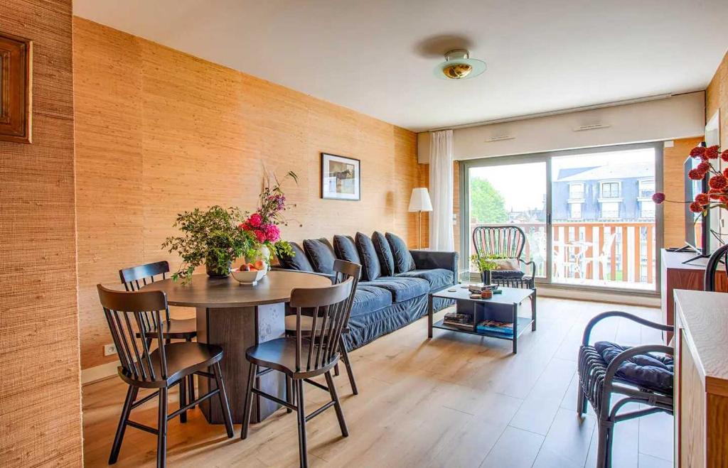 un salon avec un canapé et une table avec des chaises dans l'établissement Charming Apt w- large Balcony - 2BD-4P - Deauville, à Deauville