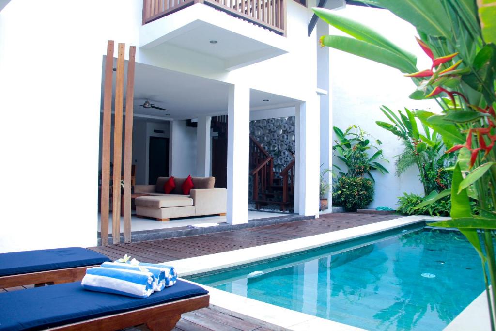 a villa with a swimming pool and a house at Delu Villas & Suite in Kerobokan