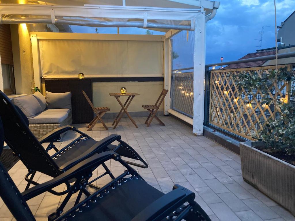 a patio with a couch and a table on a balcony at Monolocale con ampio terrazzo in Milan
