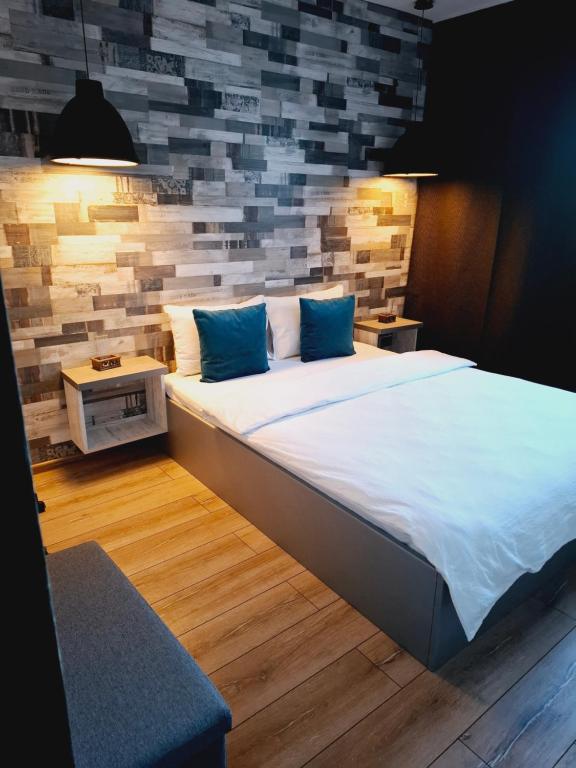 a large bed with blue pillows in a room at New Grey Apartament in Reghin