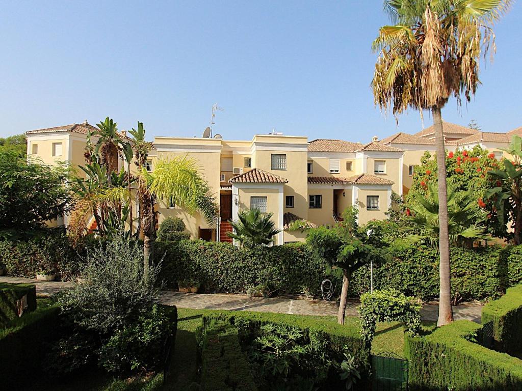 a large house with palm trees and bushes at Valparaiso Apartment Burriana Beach in Nerja