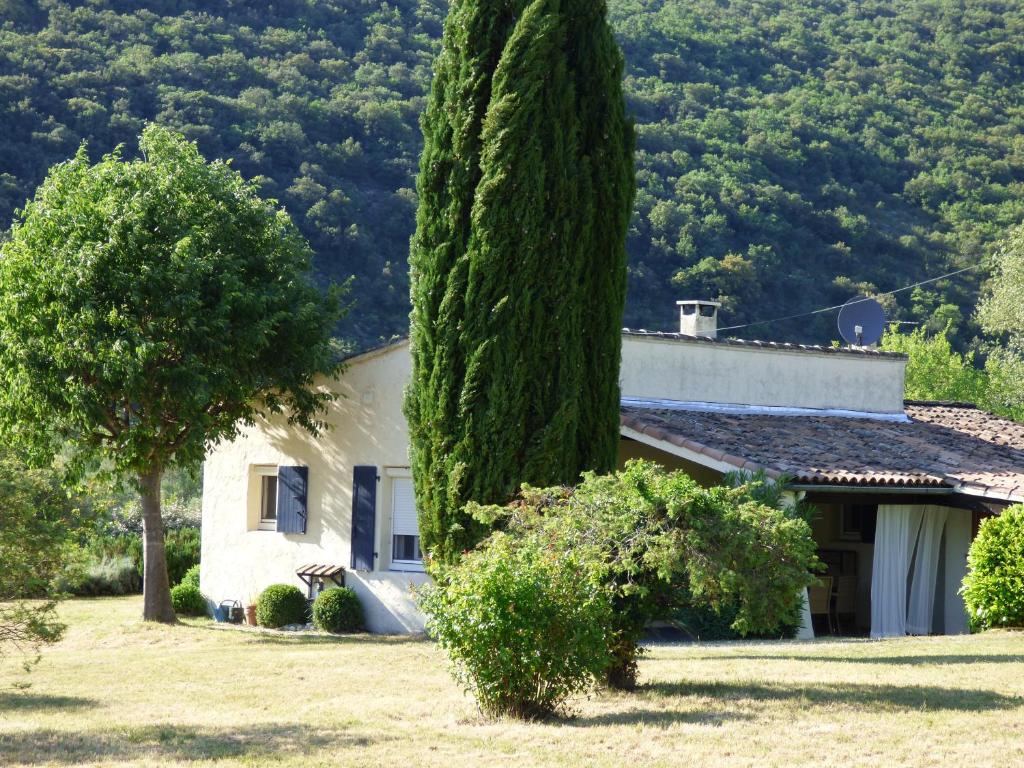 una casa con un grande albero nel cortile di Le Paradis de l'Ibie a Saint-Maurice-dʼIbie