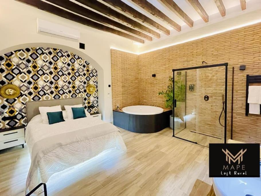 a bedroom with a large bed and a bath tub at Winahost Algar Rural in Algar