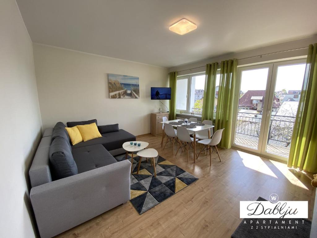 a living room with a couch and a table at W Dablju - Apartementy nad morzem in Władysławowo