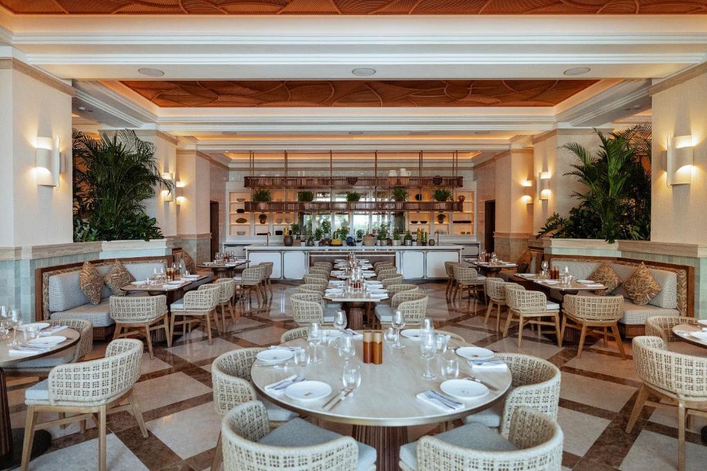 a restaurant with tables and chairs and a bar at Amara - Sea Your Only View™ in Limassol