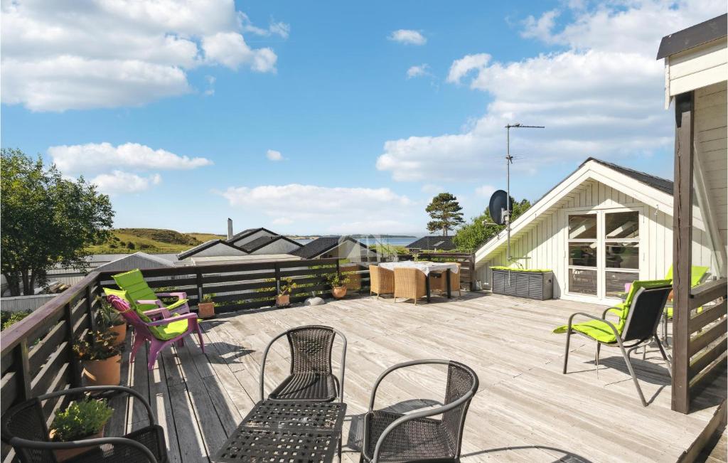 a deck with chairs and tables on a house at Three-Bedroom Holiday Home In Knebel in Knebel
