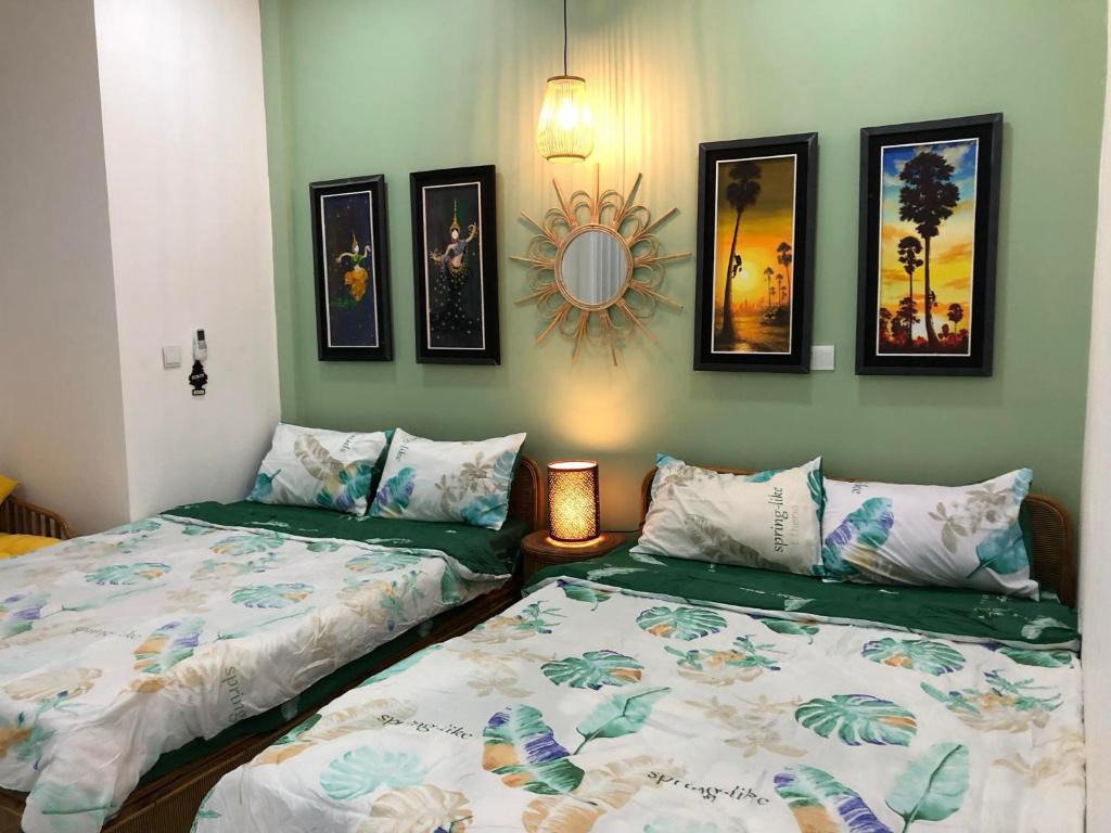 two beds sitting next to each other in a room at La Tropicale de Siem Reap in Phumĭ Kruŏs