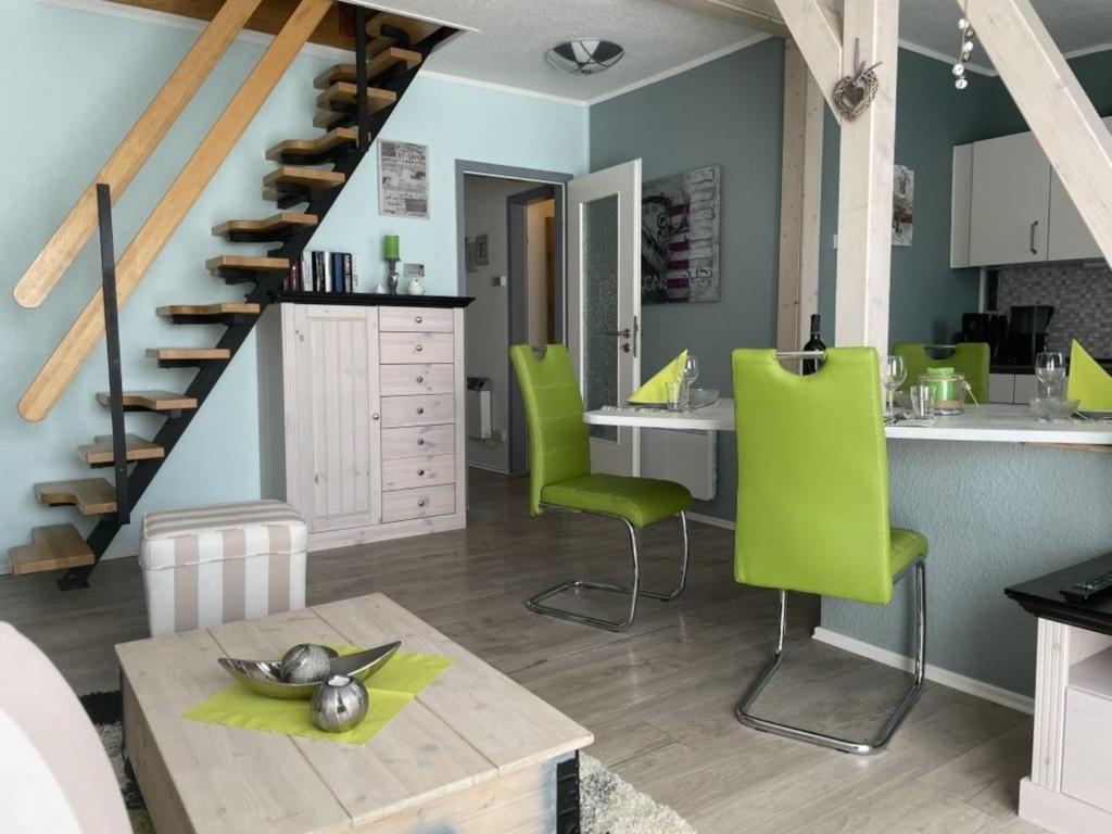 a kitchen with green chairs and a staircase at Ferienhaus DolceVita in Walkenried