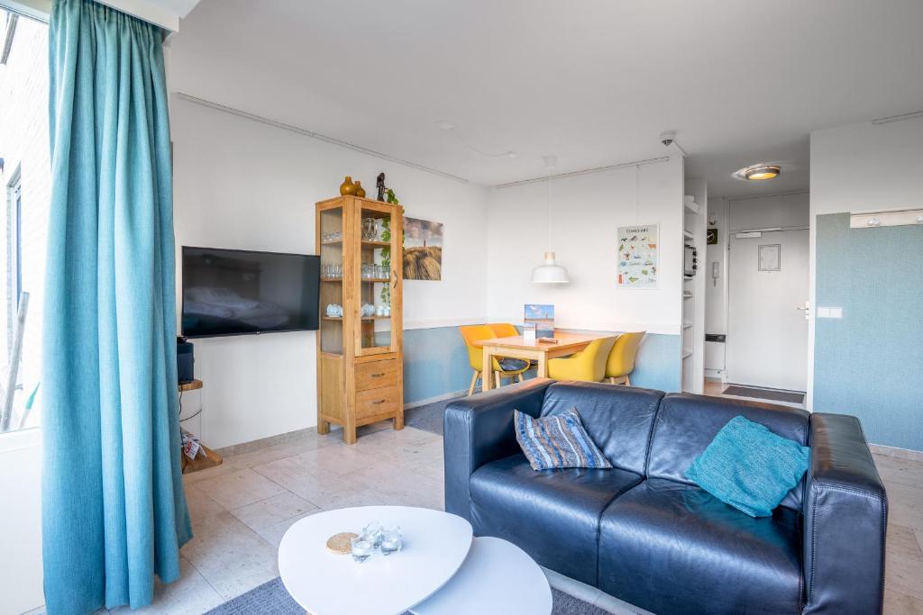 Una sala de estar con un sofá de cuero y una mesa. en Appartementencomplex Juliana 68, en De Koog
