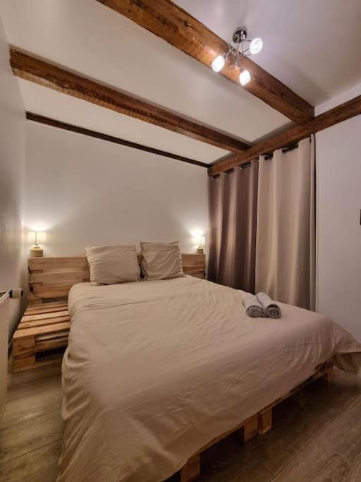 une chambre avec un grand lit dans une pièce dans l'établissement Le Hameau Frontalier, à Buschwiller